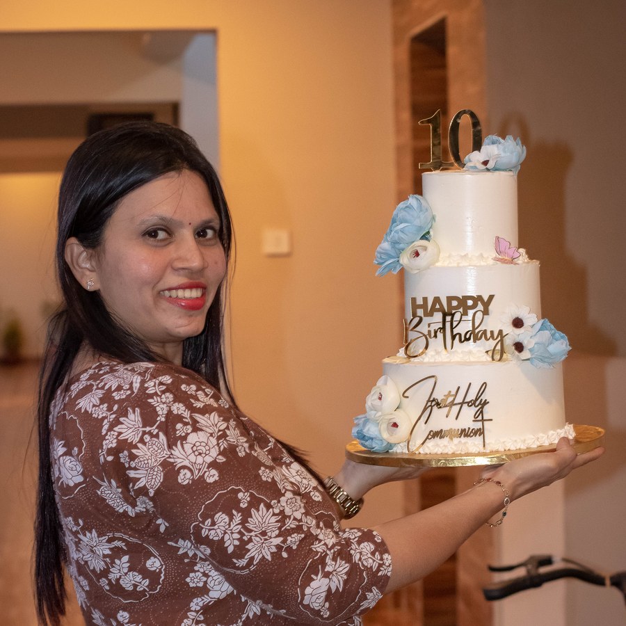 The baker behind Creamy Delight with one of her custom tiered cakes